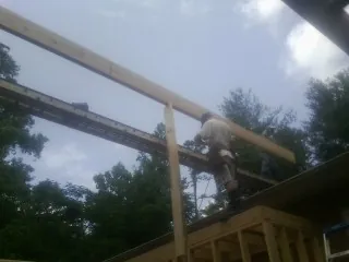 Carpenter setting a ridge beam over a new addition frame — Ice Dam Removal by Roofing Brothers in West Edmeston