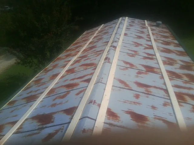Rusted metal roof panels with new wood purlins before replacement — Storm Damage Roof Repair in West Edmeston by Roofing Brothers