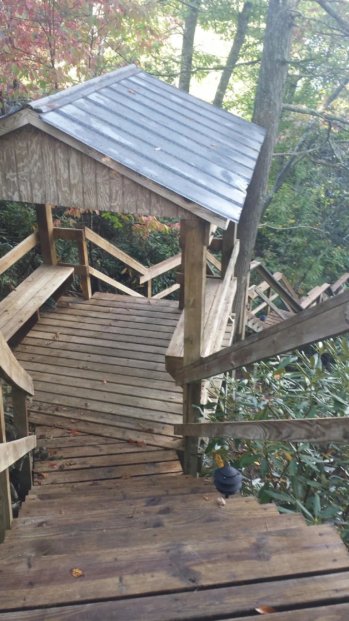 Metal roofed shelter over wooden steps on a wooded walkway — Skylight Repair & Installation work by our crew in West Edmeston