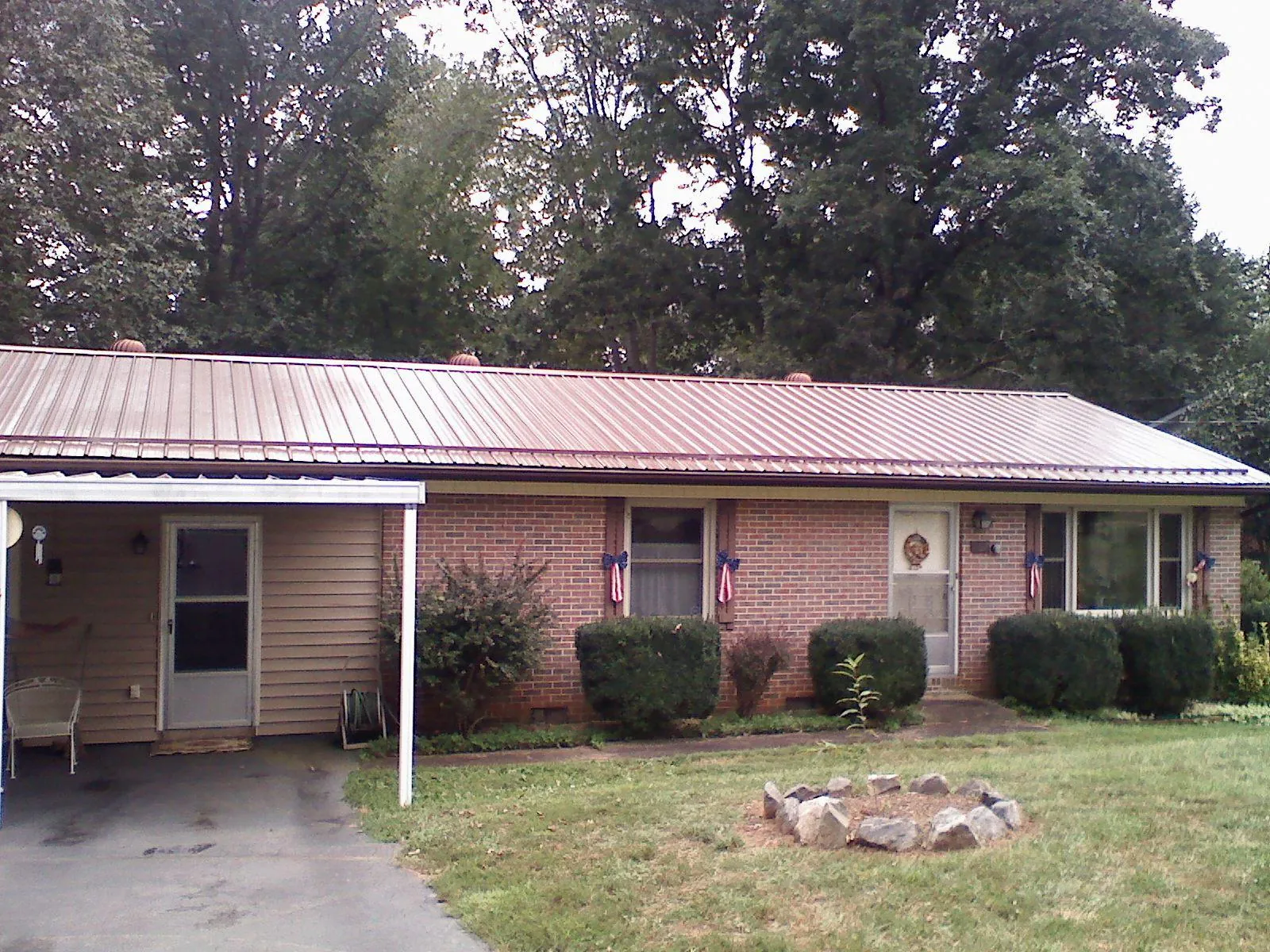 Bronze metal roof and carport on a brick ranch home — Roof Repair work by our crew in West Edmeston